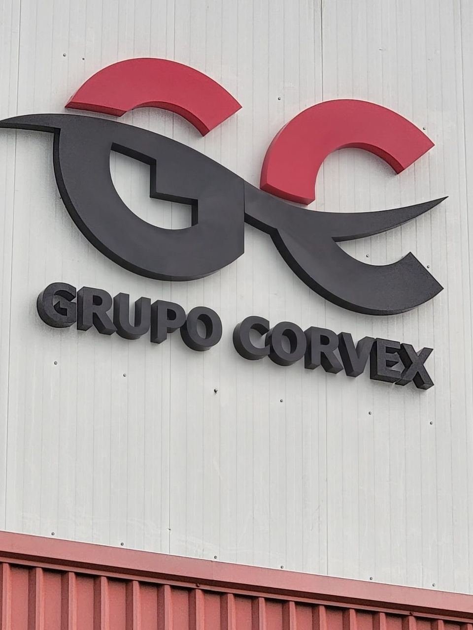 Letrero de Grupo Corvex en nave industrial, de día