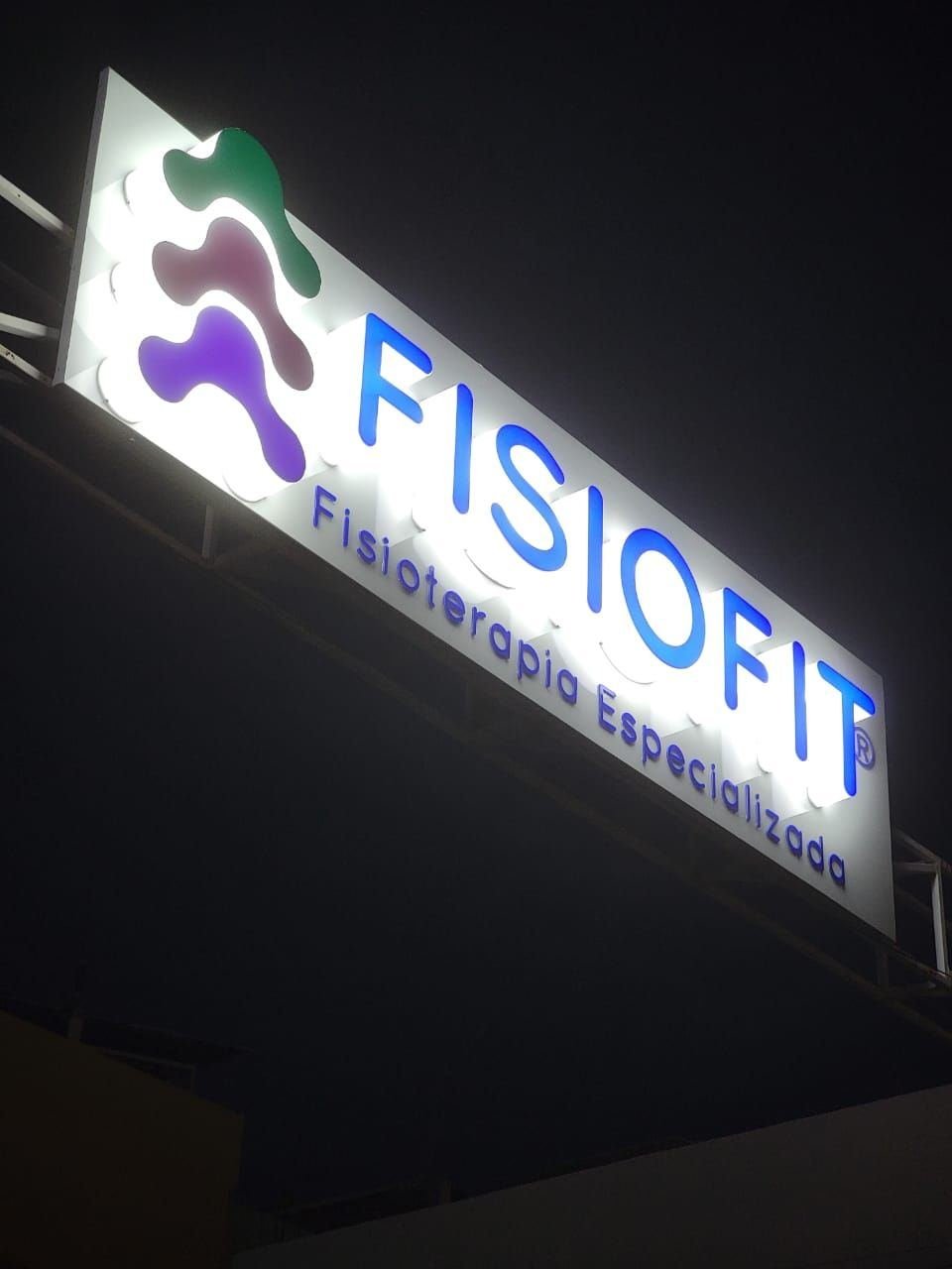 Letrero de Fisiofit iluminado de noche