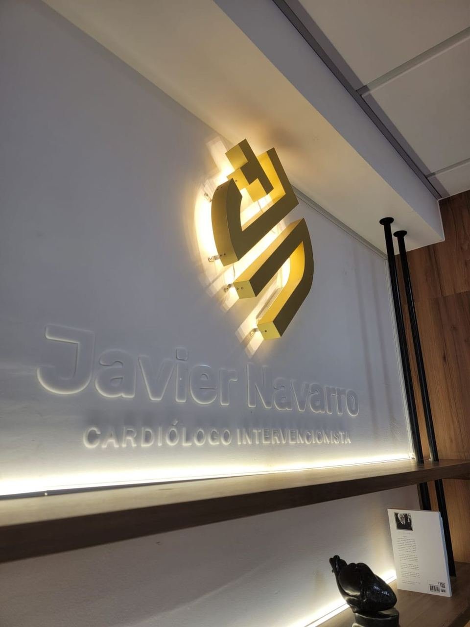 Logotipo dorado retroiluminado en consultorio